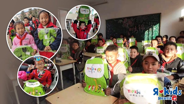 孩子们在收到玩具反斗城的爱心书包后露出了灿烂的笑容，校园里处处洋溢着欢乐和喜悦